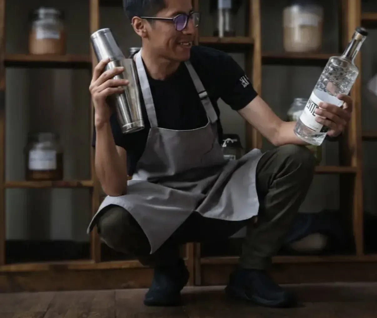 Integrante del equipo de Nativa con coctelera y botella