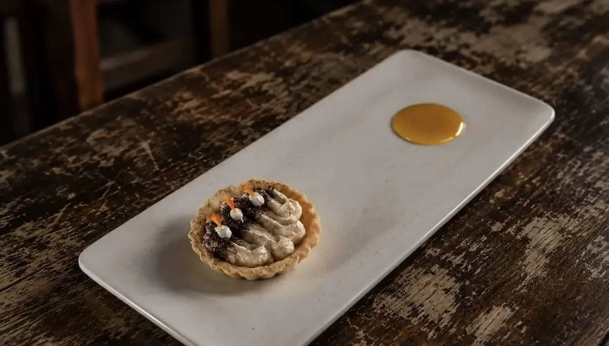 Tarta de lacayote con gota de reducción en plato alargado